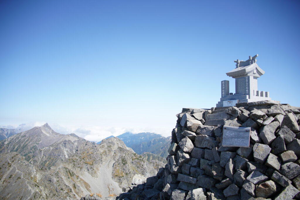 奥穂高岳山頂 写真左には槍ヶ岳(奥穂高岳山頂で撮影)