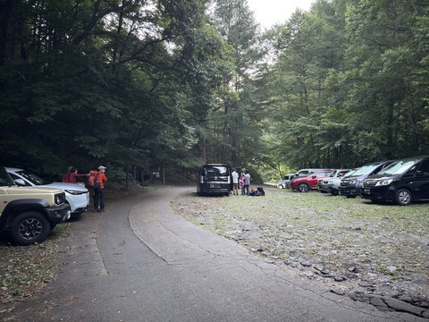早朝の桂小場登山口駐車場。ヘッドライトをつけた登山者が出発の支度をしている