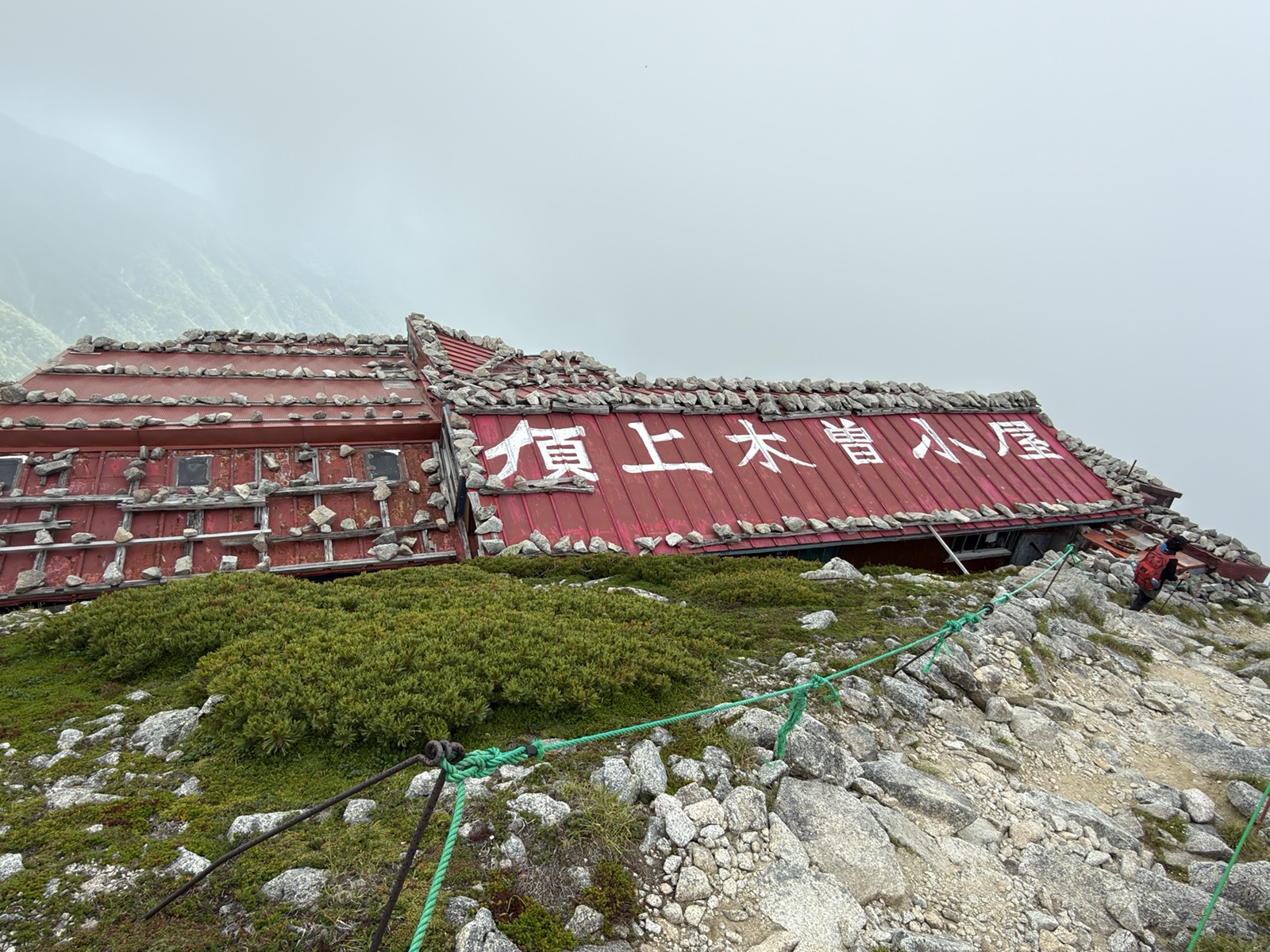 頂上木曽小屋。赤いトタン屋根に石が並べて載せてある