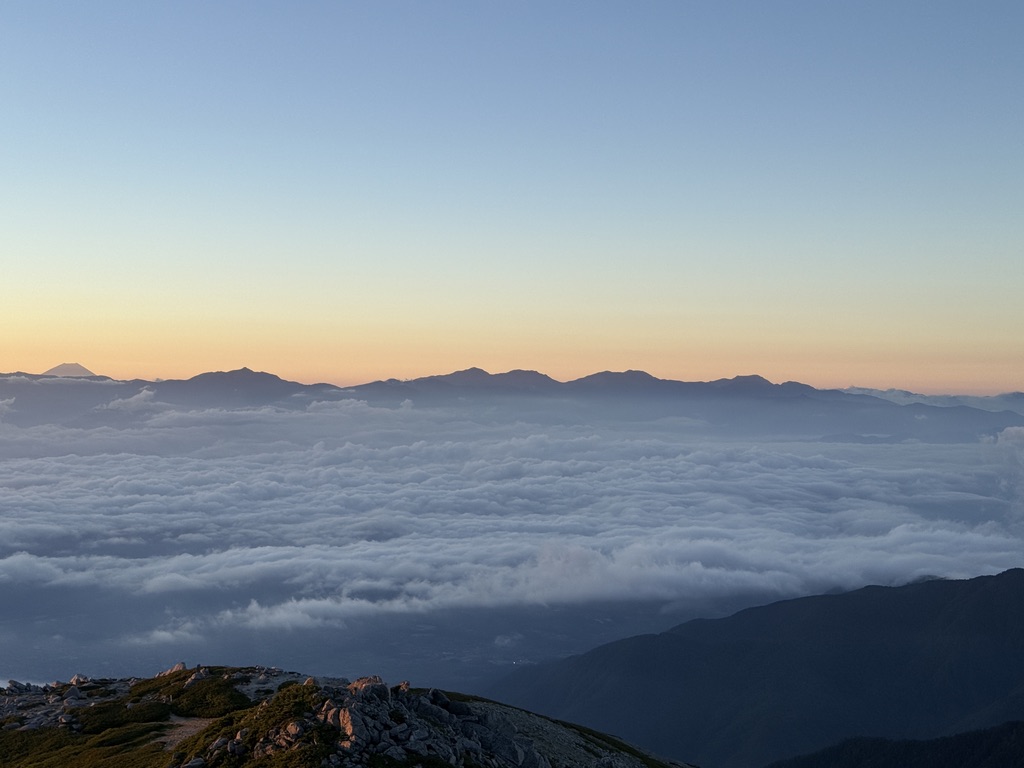 夜明けの雲海と南アルプス(南部)のシルエット。左に富士山