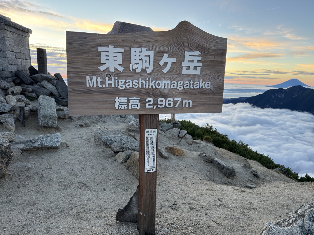 同じ標柱の裏面「東駒ヶ岳 Mt.Higashikomagatake 標高2,967m」。右奥に富士山