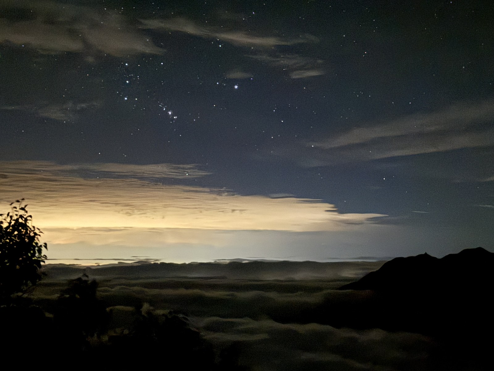 オリオン座が写った星空と、雲海の下の街明かり