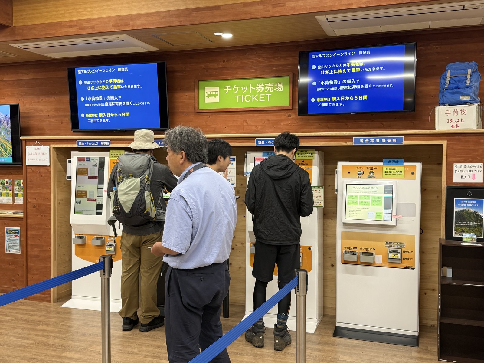 仙流荘の券売場内部。券売機と、右上に「手荷物 18L以上 有料」の札