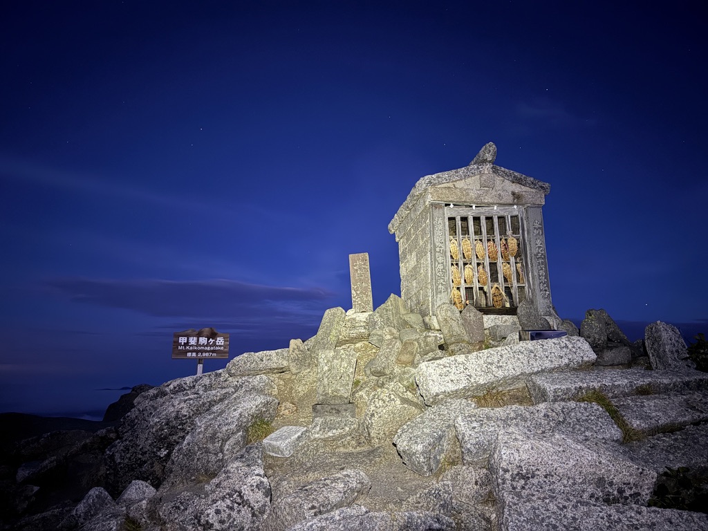 夜明け前の甲斐駒ヶ岳の山頂と、ヘッドランプで照らした祠