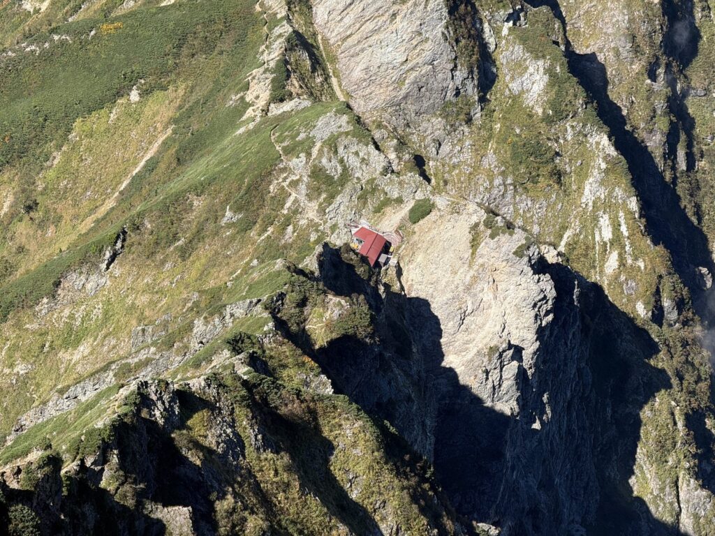 鹿島槍ヶ岳北峰から見下ろした八峰キレット方面の岩稜と、赤い屋根の小屋
