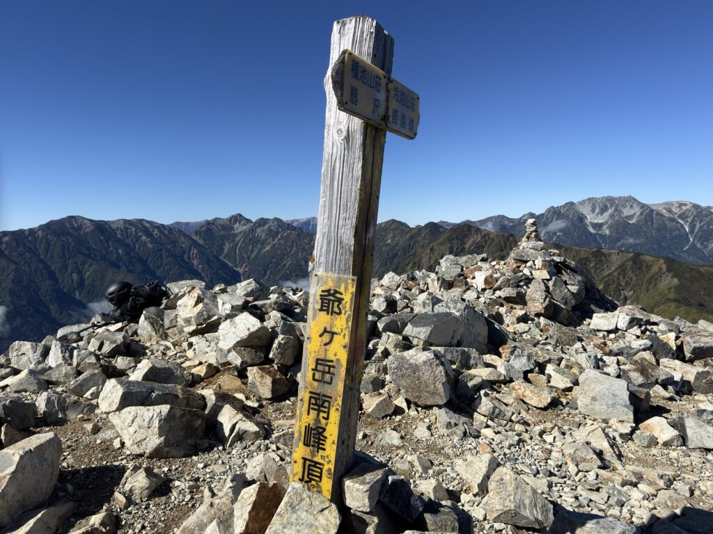 爺ヶ岳南峰の標柱「爺ヶ岳南峰頂」と、背景の剱・立山方面の山並み