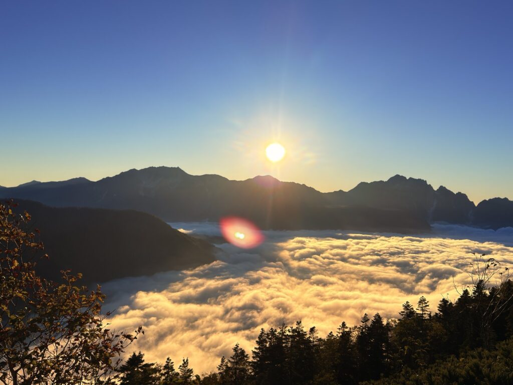 剱岳・立山の稜線に沈む夕日と、金色に染まる雲海