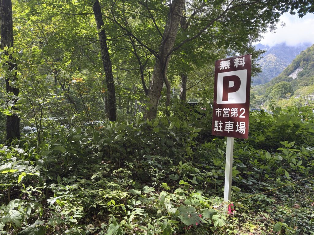 林の中に立つ「無料 市営第2駐車場」の看板