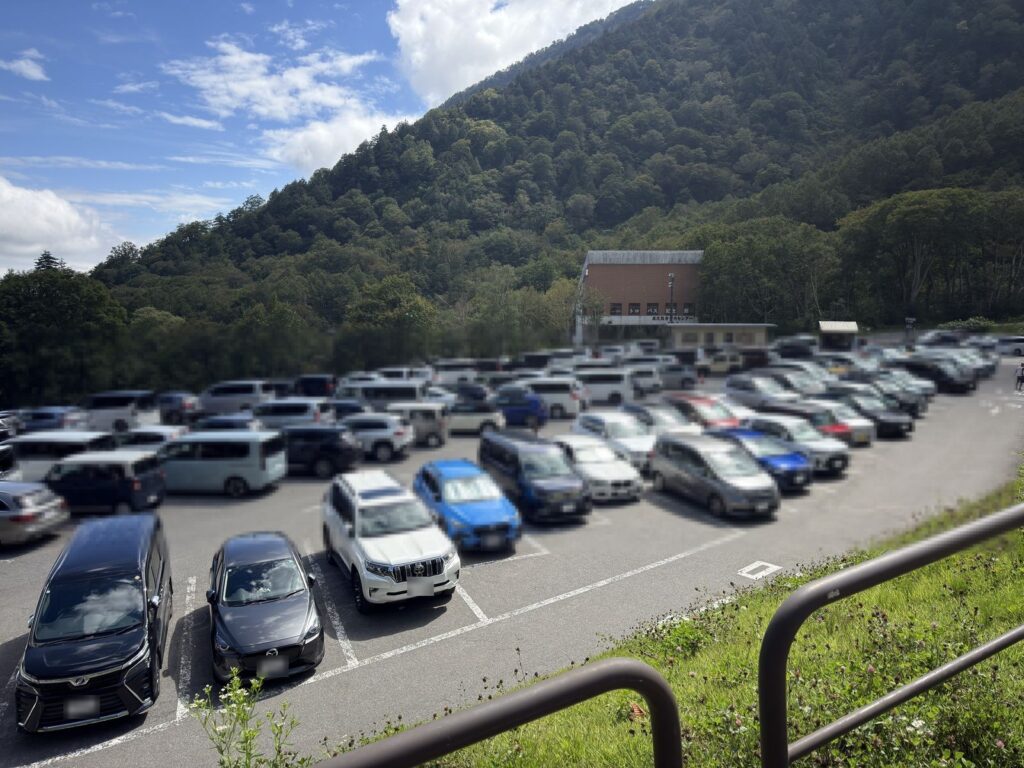 扇沢駅前に広がる舗装された駐車場と車の列