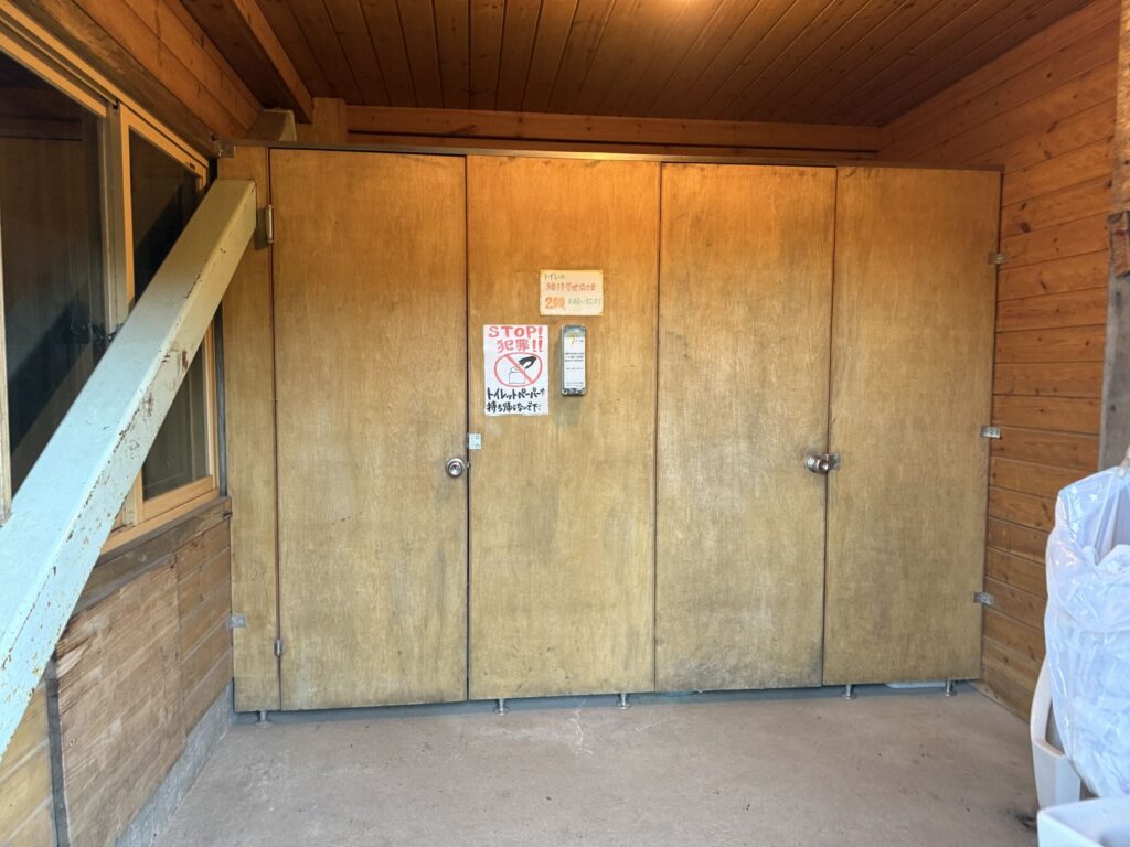 外トイレの中。「トイレの維持管理協力金 200円」の貼り紙