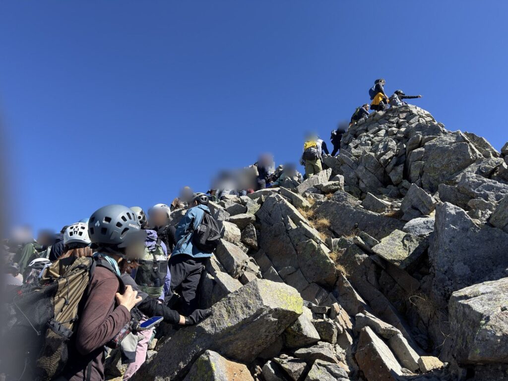 奥穂高岳の山頂。標識の前は撮影待ちの人