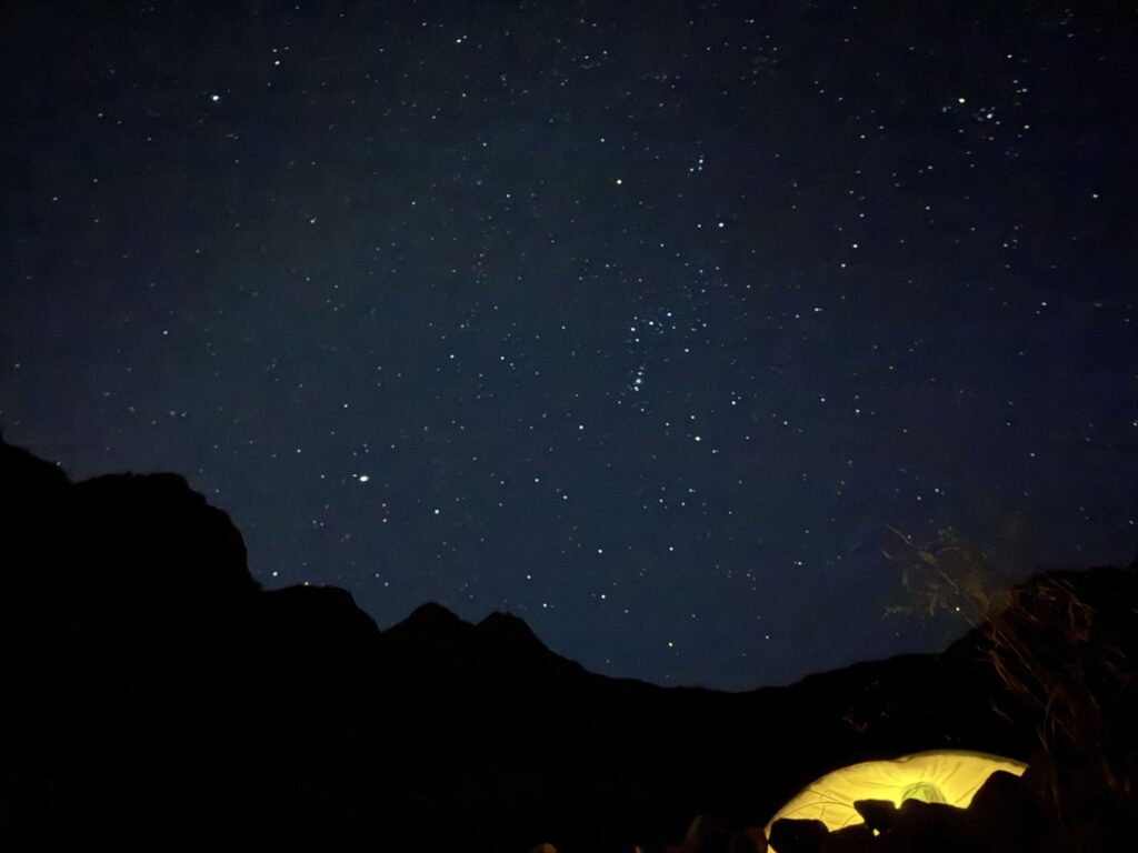 3日目の4時49分。星空と、自分のテントの灯り