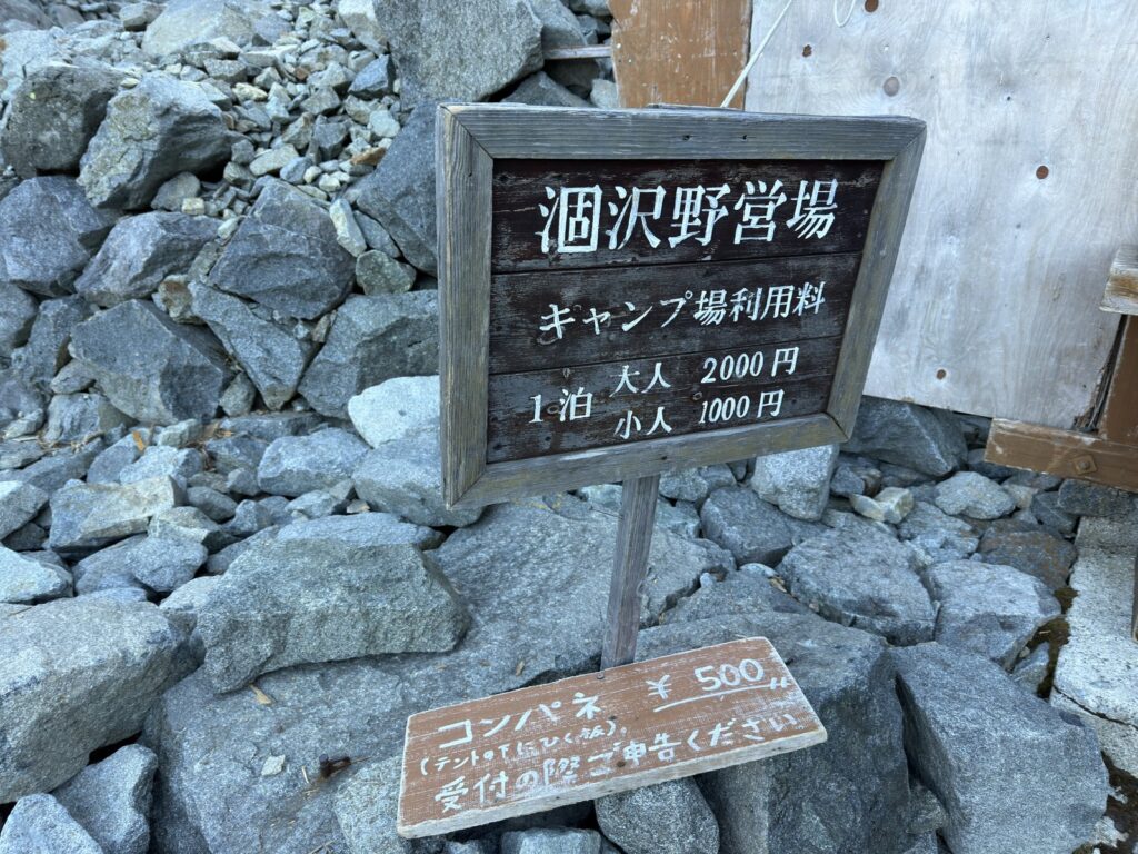 受付の前の看板。1泊大人2,000円・小人1,000円、コンパネ500円